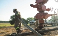 man with hose at wellhead