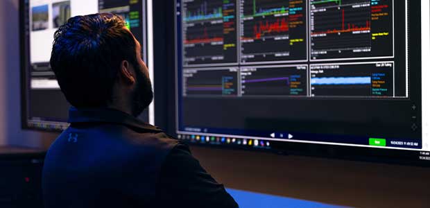 Man looking at data on monitors